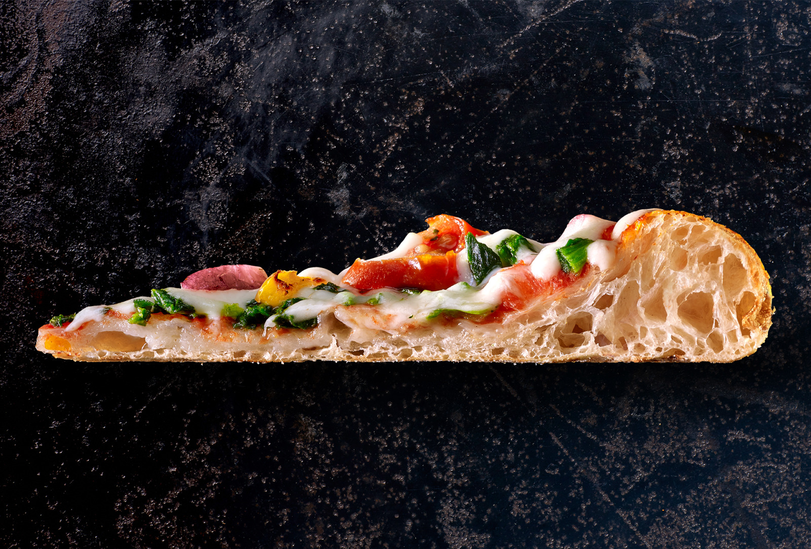 Wagner vegetable pizza slice showing melted cheese and an airy crust.